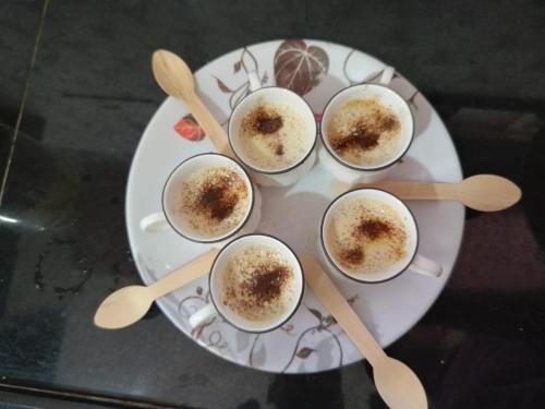 un piatto bianco con quattro tazze di cibo sopra di SHRISHAILAM FARM AND YATRI NIWAS a Akalkot