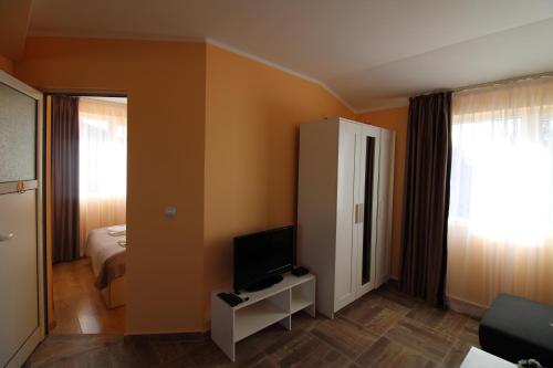 a small room with a bed and a television at Къща за гости Света Марина in Krapets