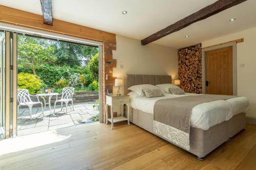 sypialnia z łóżkiem i przesuwnymi szklanymi drzwiami w obiekcie The Old Cow Shed w mieście Grimston
