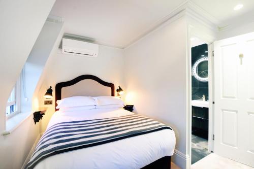 a white bedroom with a black and white bed at Twenty Nevern Square Hotel in London