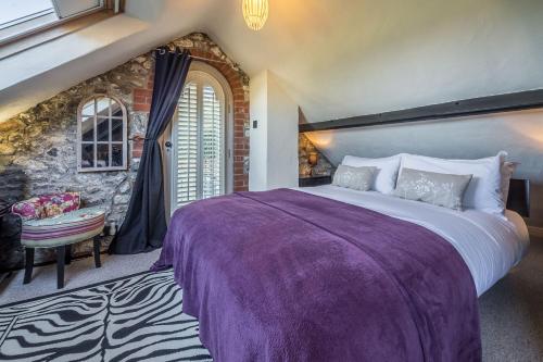 Holme next the SeaにあるThe Old Smithyの石壁のベッドルーム1室(大型ベッド1台付)