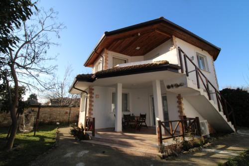 a small white house with a wooden roof at Къща за гости Света Марина in Krapets