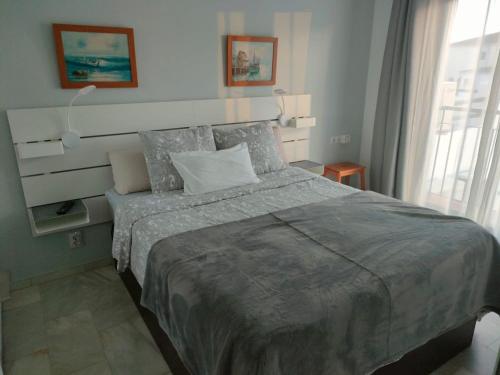 ein Schlafzimmer mit großem Bett und Fenster in der Unterkunft 1 Bedroom Apartment in Pueblo Evita in Arroyo de la Miel