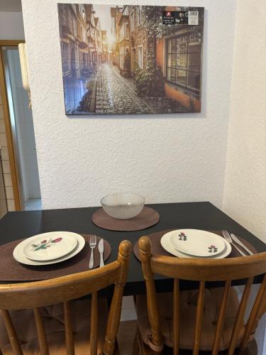 una mesa con dos sillas y platos en ella en City Wohnung 12, en Brühl