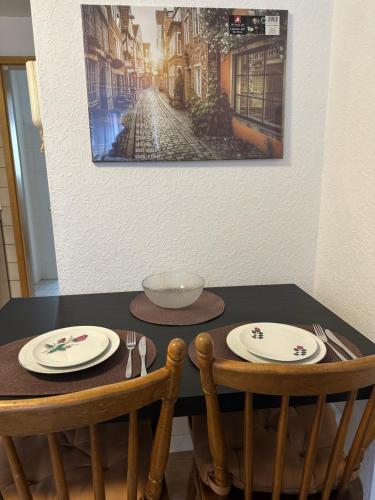 a table with two chairs and plates on it at City Wohnung 12 in Brühl