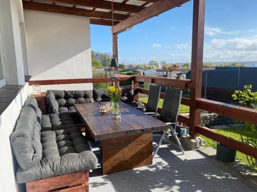 eine Terrasse mit einem Holztisch und einem Sofa in der Unterkunft Schöne Aussicht am Strand - ABC304 in Wismar