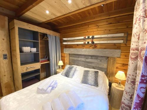 Un dormitorio con una cama en una cabaña de troncos en LE SKIEUR Chalet en bois, en La Bresse