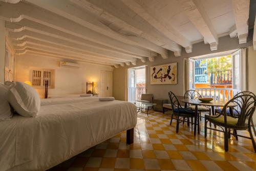 a bedroom with a bed and a table and chairs at Casa Ámbar Cavelier in Cartagena de Indias