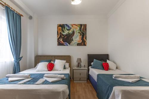 two beds in a room with a painting on the wall at Villa Yazır in Antalya