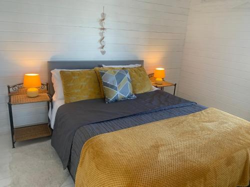 - une chambre avec un lit et 2 lampes dans l'établissement Peaceful Log Cabin next to Horse Field, à Morpeth
