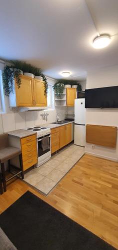 a kitchen with wooden cabinets and white appliances at Studio apartment near metro and forest! in Stockholm