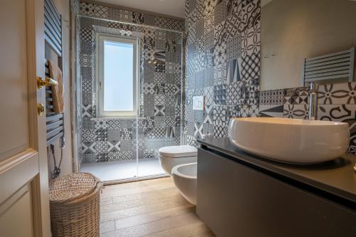 a bathroom with a sink and a toilet and a shower at Sunset View by Firenze Prestige in Quercianella