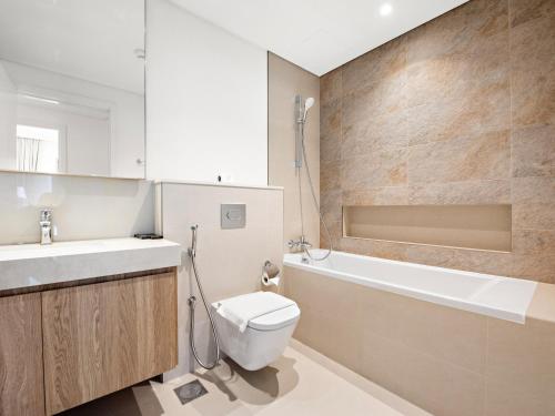 a bathroom with a toilet and a sink and a bath tub at Brand New Elegant 1BDR Direct Access to Dubai Mall in Dubai