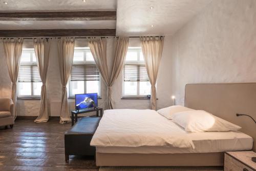 a bedroom with a bed and a chair and windows at Lodge am Oxenweg in Husum