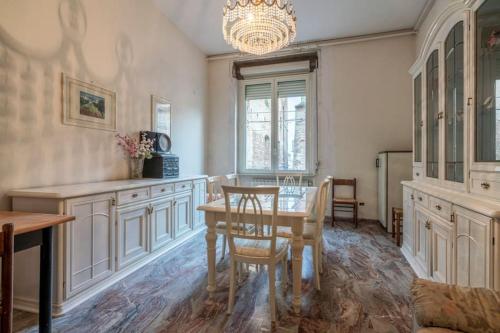 a dining room with a table and a chandelier at la casa di Za' Rosina in Monteodorisio