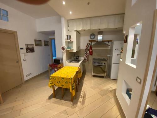 a kitchen with a yellow table in the middle of it at Domus Janiculum Roma Gianicolo in Rome