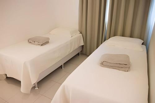 two beds in a hospital room with white sheets at Executive In - Ideal para família in Rio de Janeiro