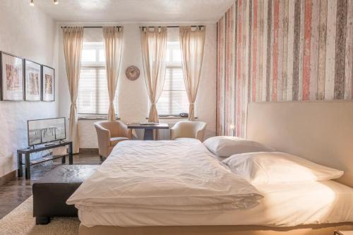 a bedroom with a large white bed and a table at Lodge am Oxenweg - Zimmer 1 in Husum