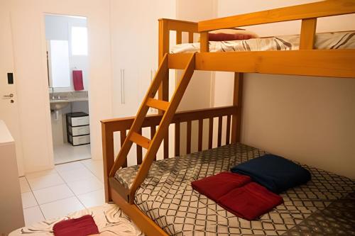 a bunk bed with two red and blue pillows on it at Ideal para famílias! Muita segurança in Rio de Janeiro