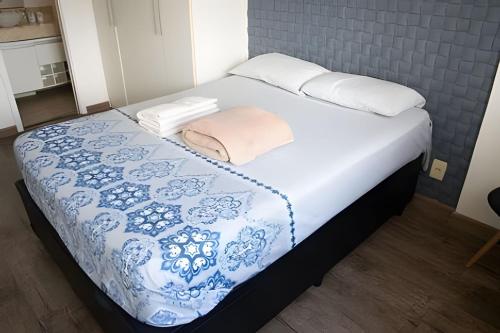 een bed met een blauwe en witte deken en kussens bij Loft Executivo - Ideal para família. in Rio de Janeiro