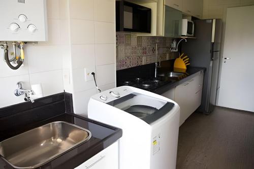 una pequeña cocina con fregadero y fregadero en Loft Executivo - Ideal para família. en Río de Janeiro