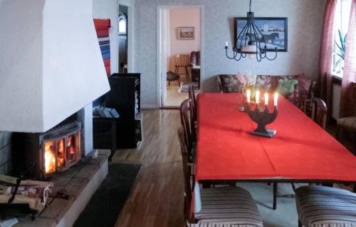 a dining room with a red table and a fireplace at Amazing Home In Jrpen With House A Mountain View in Järpen