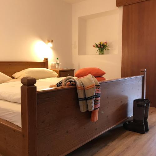 a bedroom with a wooden bed with a blanket on it at Gästehaus Hotel Maria Theresia in Schliersee