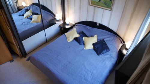 um quarto com 2 camas com lençóis e almofadas azuis em Ferienwohnung Fuchsblick em Altenau