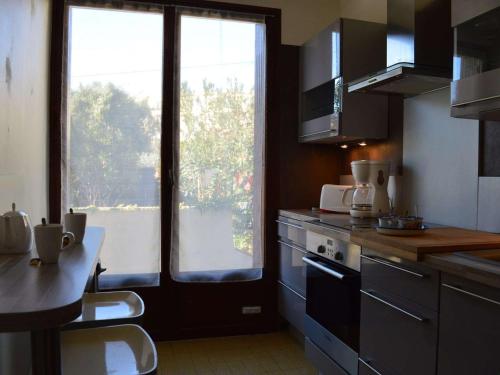 une cuisine avec une grande fenêtre et un comptoir de cuisine dans l'établissement Maison 4 pièces avec terrasse, climatisation et parking - Proche plage à Fréjus - FR-1-226A-48, à Fréjus