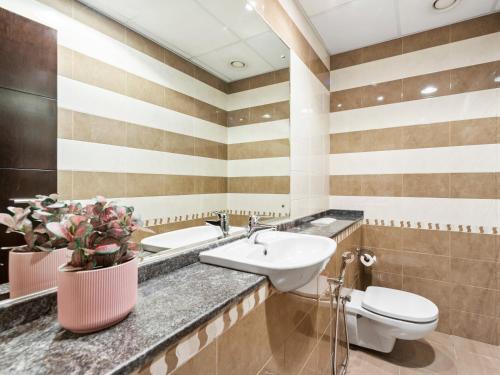 a bathroom with a sink and a toilet at Brand New 2 Bedroom in La Fontana - 205 in Dubai
