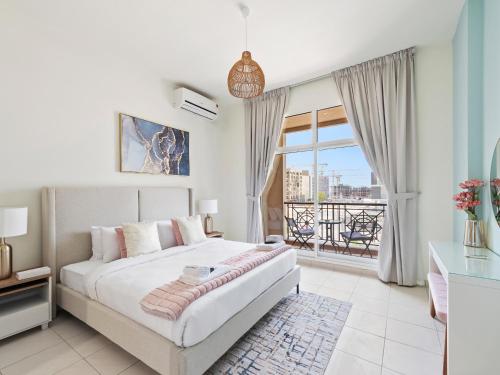 a bedroom with a bed and a large window at Brand New 2 Bedroom in La Fontana - 205 in Dubai