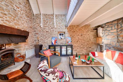 un salon avec un canapé et une cheminée dans l'établissement Escapade dans une belle longere a Penmarch, à Penmarcʼh