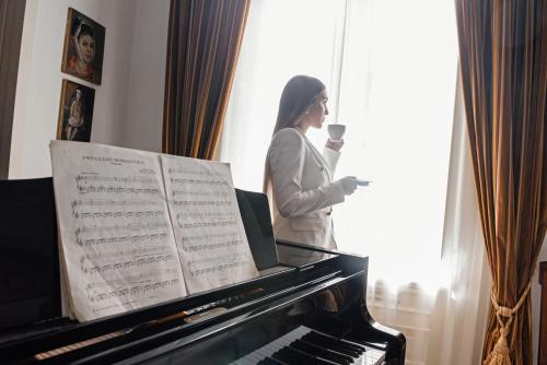 a woman standing next to a piano with a glass of wine at Al centro Luxury Home in Caserta