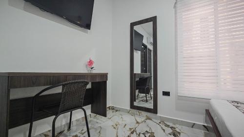 a room with a mirror and a chair and a table at ZAFIRO HOTEL in Doradal