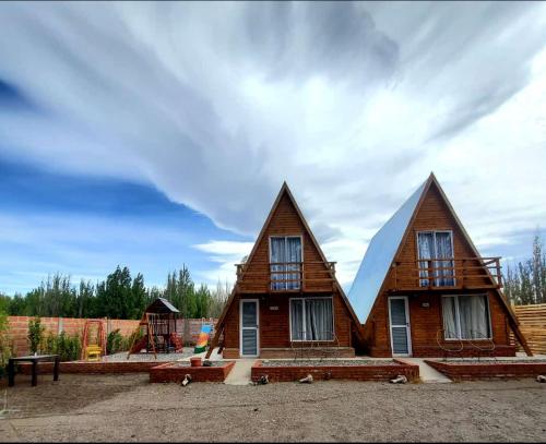 ein Haus mit zwei spitzen Dächern darüber in der Unterkunft Cabañas alpinas alumine in Perito Moreno