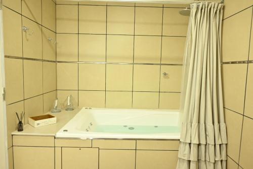 a bath tub in a bathroom with a shower at Casa El Hornero Concepción del Uruguay in Concepción del Uruguay