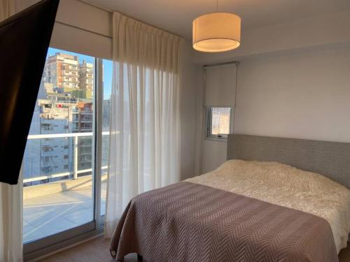 a bedroom with a bed and a large window at Moderno y luminoso in Buenos Aires