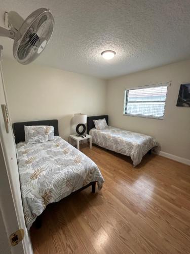a bedroom with two beds and a fan at Delightful 3 Bdrm Home, Mins to Clearwater Beach in Clearwater