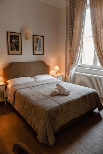 a bedroom with a large bed with two windows at Al centro Luxury Home in Caserta