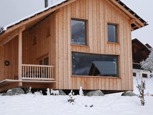 a house with cats standing outside of it in the snow at Ferienhäuser Stiva Pintga in Somvix