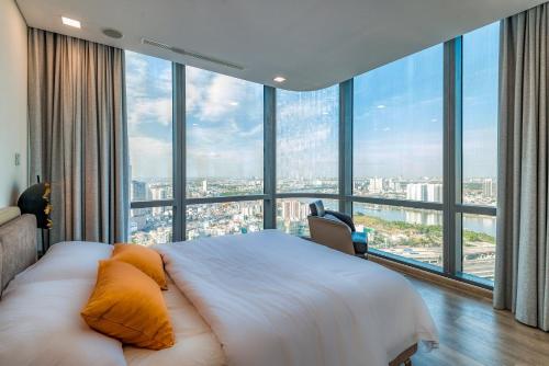 a bedroom with a large bed and large windows at Landmark 81 And Vinhomes PANORAMA - ANGIA Hospitality in Ho Chi Minh City