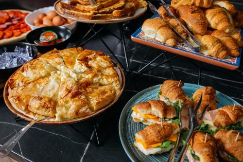 a table with plates of food and pies and pastries at Nobel Gallery Hotel in Belgrade