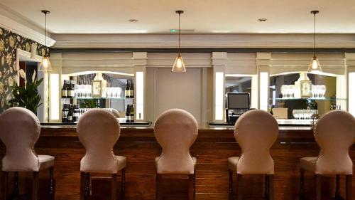 a bar with five chairs in front of a practition at Cill Aodain Court Hotel in Kiltimagh