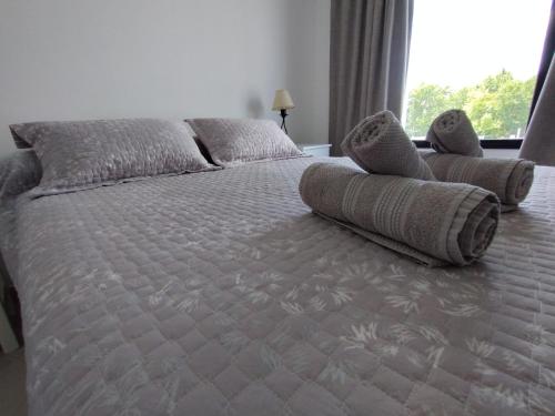 een slaapkamer met een groot bed en handdoeken bij Valle Serrano II Departamentos in Tandil