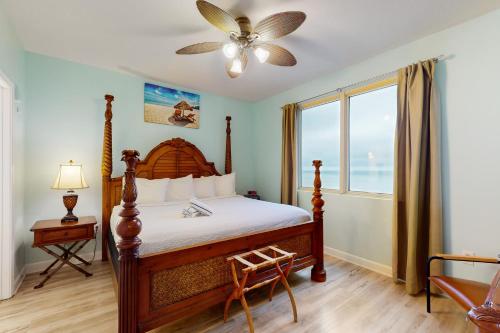 a bedroom with a bed with a fan and a window at Shores of Panama 1318 in Panama City Beach