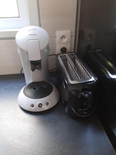 a white and black mixer sitting next to a toaster at Caraïbes Cottages Le Jasmin vue mer a 500m de la plage in Deshaies