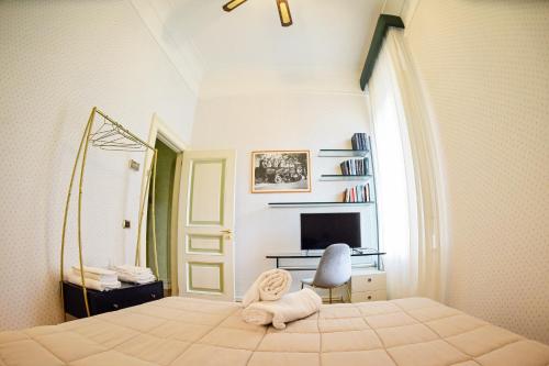 a bedroom with a bed with a chair and a television at Al centro Luxury Home in Caserta