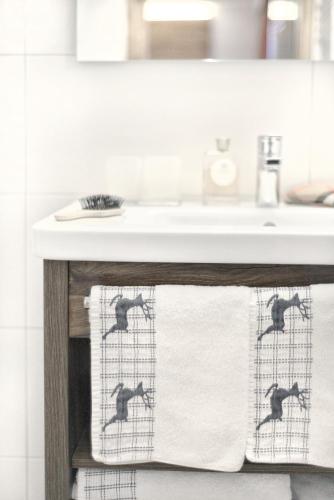 a bathroom sink with monkey towels on a towel rack at Hotel Alpina Superior in Pettneu am Arlberg