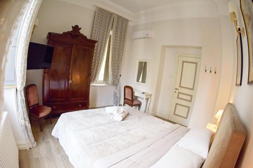 a bedroom with a large white bed and a chair at Al centro Luxury Home in Caserta