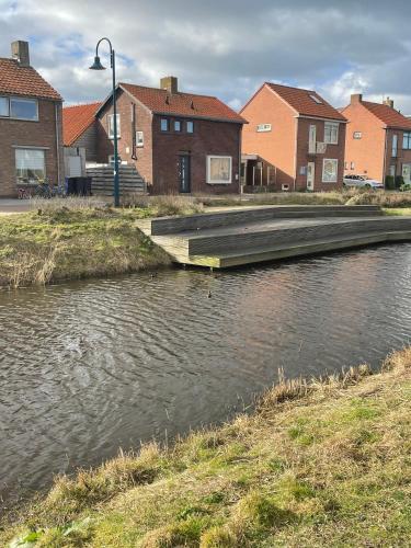 a bridge over a river with houses in the background at Puur Texels 9a in De Koog